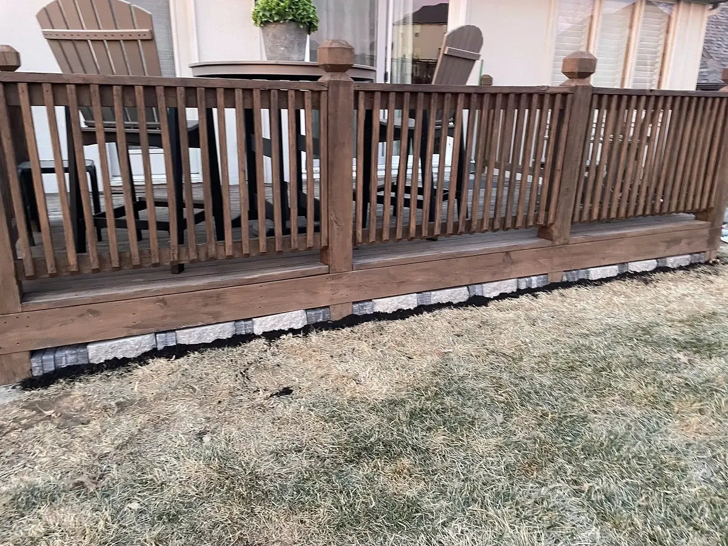 Decorative rock laid and bordered under a deck run, keeping mud and splash-back off the framing.